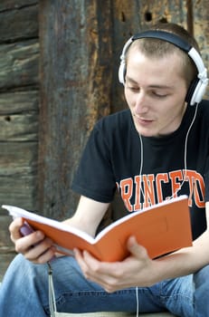 Man listening to the music in a park with white headphones