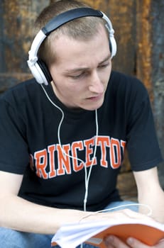 Man listening to the music in a park with white headphones