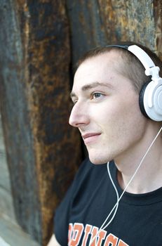 Man listening to the music in a park with white headphones