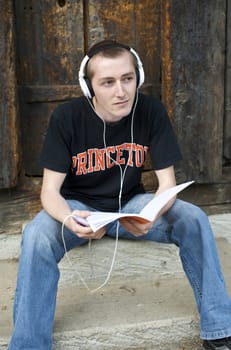 Man listening to the music in a park with white headphones