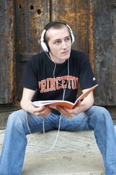 Man listening to the music in a park with white headphones