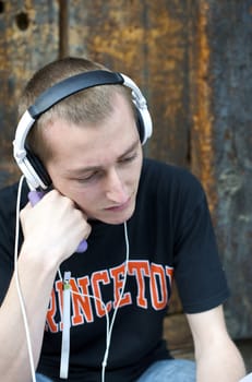 Man listening to the music in a park with white headphones