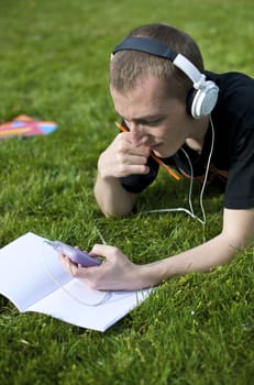 Man listening to the music in a park with white headphones