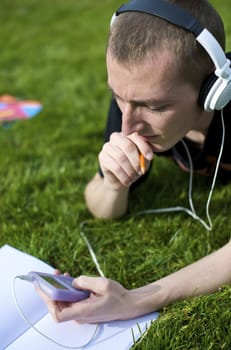 Man listening to the music in a park with white headphones