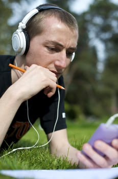 Man listening to the music in a park with white headphones