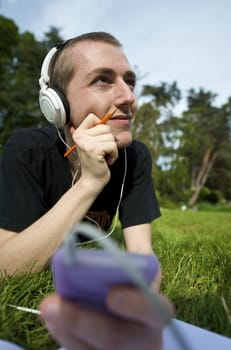 Man listening to the music in a park with white headphones