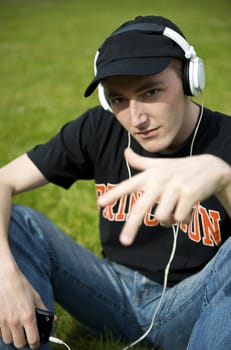 Man listening to the music in a park with white headphones