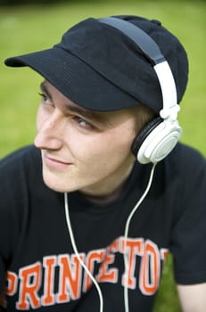 Man listening to the music in a park with white headphones