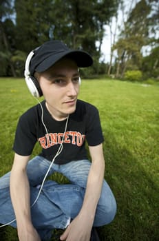 Man listening to the music in a park with white headphones