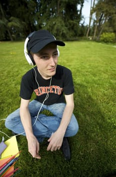 Man listening to the music in a park with white headphones