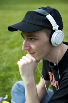 Man listening to the music in a park with white headphones