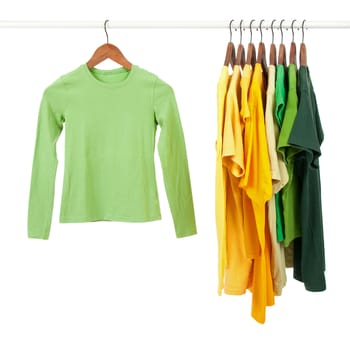 Green and yellow casual shirts on wooden hangers, isolated on white.
