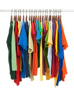 Variety of multicolored casual shirts on wooden hangers, isolated on white.