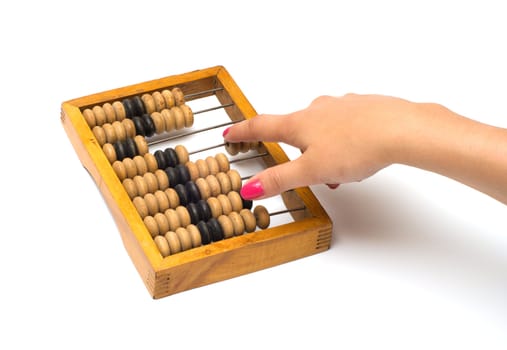 Female hand on old wooden an abacus it is isolated on a white background.