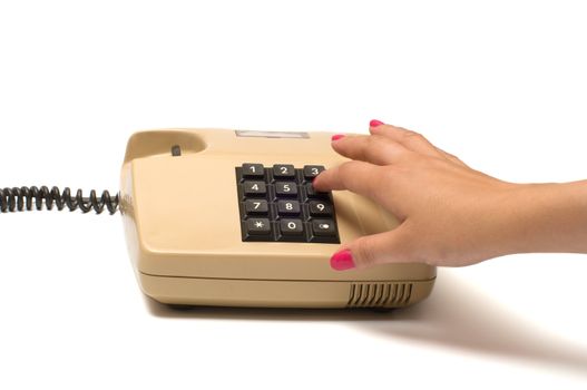 Female finger presses the button on the old phone isolated on white background.