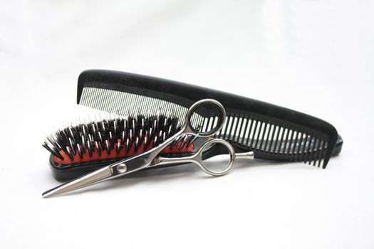 Basic hairdressers tools: pair of scissors, a brush and a comb