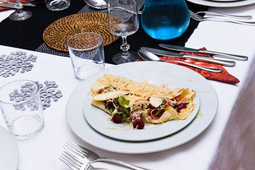 Plate with entree on set table with winter decoration