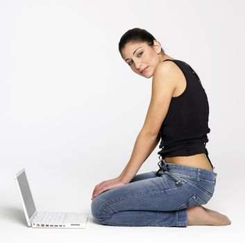 Pretty young girl sitting on floor with laptop