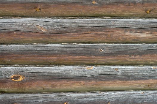 Fragment of a wall of an old rural log house.