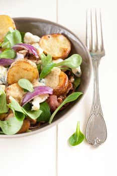 Healthy fresh salad with roasted potatoes, red onions, blue cheese and lamb's lettuce