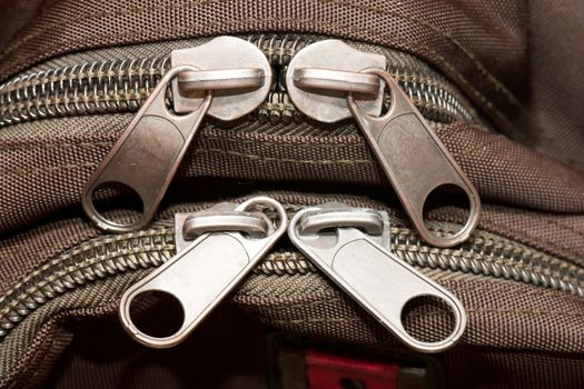 Closeup view of closed zippers on a bag.