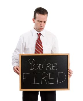 A young teacher looking down at his chalk board which says you're fired, isolated against a white background