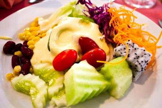 salad from fruit and vegetables on white plate