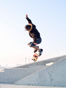 Modern teenage skater catching some air with his skateboard