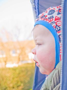 Babies - Cute little baby boy looking worried in his pram