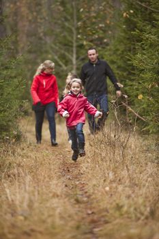 Little girl running in front of her family