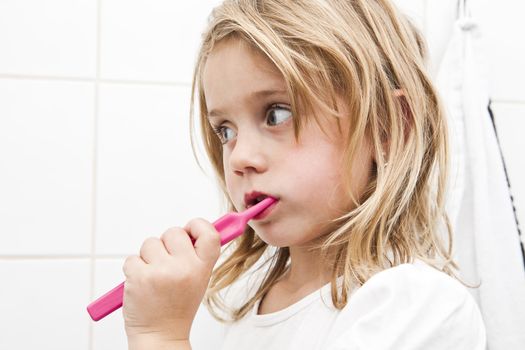 Little girl with toothbrush in the bathroom