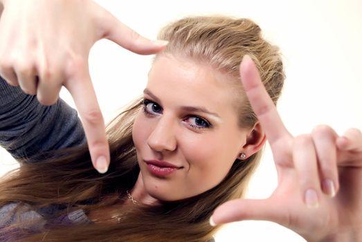 Portrait of a young beautiful girl showing framing hand gesture