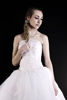 Young beautiful bride in wedding dress over black 