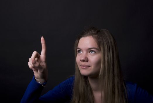 Portrait of a young beautiful girl pointing at something