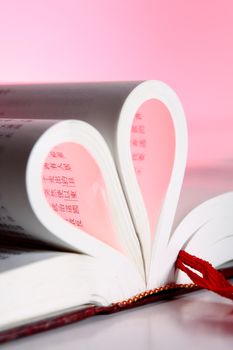 pages of a book curved into a heart shape .