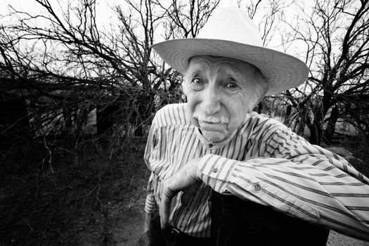 Elderly rancher with sad eyes in a straw hat