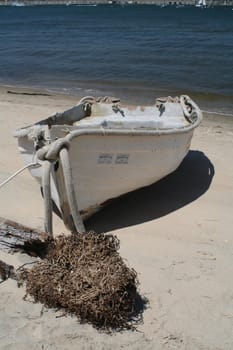 An old row boat on a white sand beach