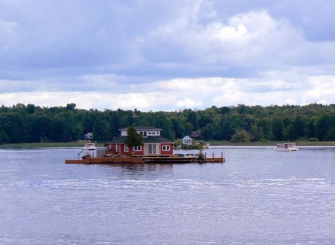 Iislands with and a red house between the thousand islands on the Ontario lake, Canada, by cloudy weather