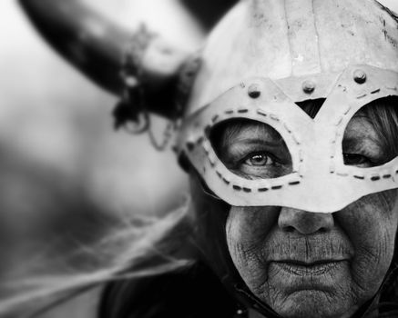Closeup portrait of Viking woman in helmet with horns