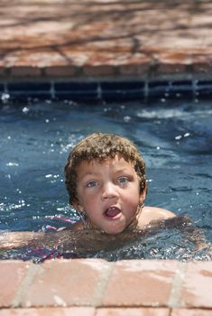 Cute young boy with blue eyes in a swimming pool