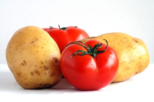 Two potatoes and two fresh tomatoes together
