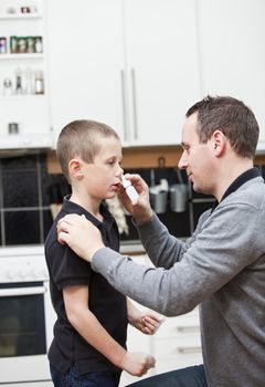 Man giving nose drops to young boy