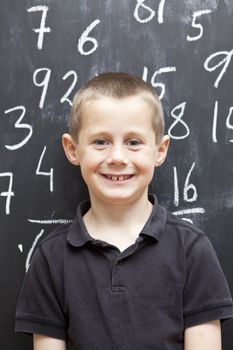 Young Boy in front of the blackboard at school