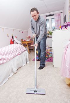 Man with a vacuum cleaner in a girls room