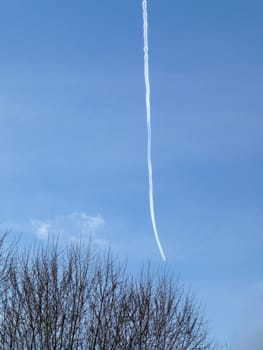 
A hard to see airplane and its chemtrail high in the blue sky.
