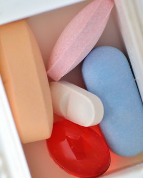 An assortment of pills in a weekly pill container.