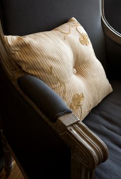Ornate stripped pillow on the old stile armchair