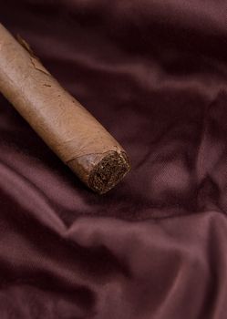 Cigar on brown silky fabric