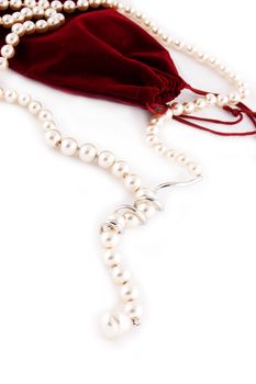 Pearl necklace and velvet bag isolated on white