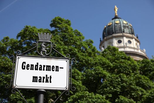 signpost at Gendarmenmarkt in Berlin/Germany with Dome in the background on a sunny day